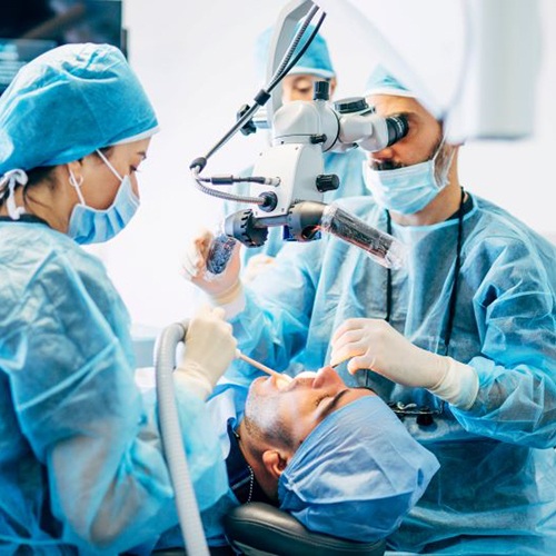 Dental team carefully performing dental implant surgery