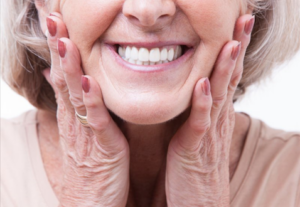 Senior woman pressing her hands to her cheeks and smiling